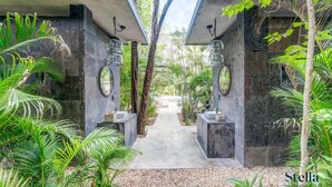 A pathway flanked by stone pillars with lanterns, leading to a pool. - Arthouse Stay with Pool, Gym, & Private Terrace (Tulum)