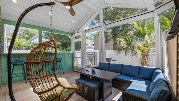 A covered outdoor seating area with wicker furniture, a hanging chair, and a ceiling fan. - Modern 4BR w/ Heated Pool | It's Always Sunny (North Myrtle Beach)