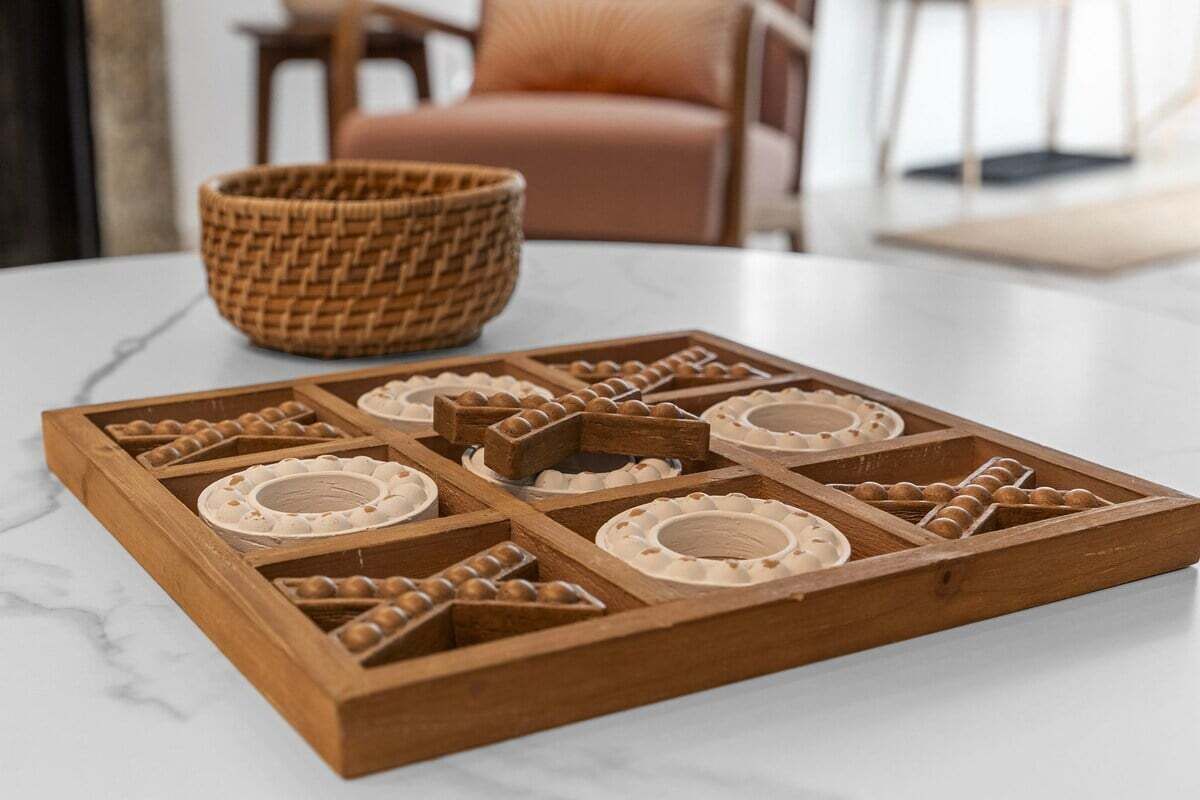 A wooden tray with multiple compartments on a marble table.