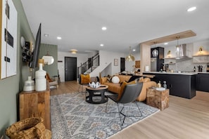 A modern living room with a sofa, coffee table, and a patterned rug.