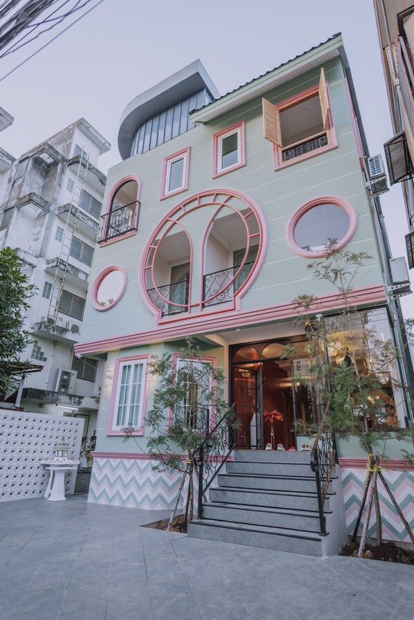 A multi-story building with a unique architectural design, featuring circular windows and balconies. - Ma Muan Budget & Boutique Chiang Mai (Chiang Mai)