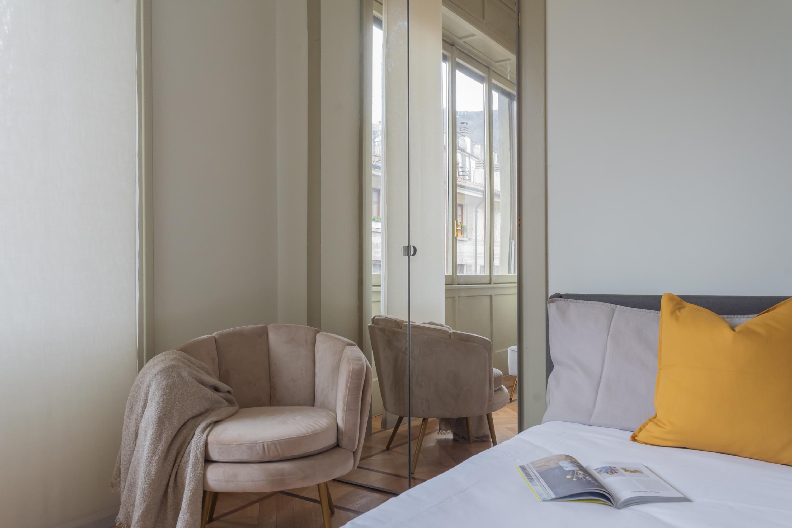 Une chambre d’hôtel avec un lit, une chaise et une fenêtre.
