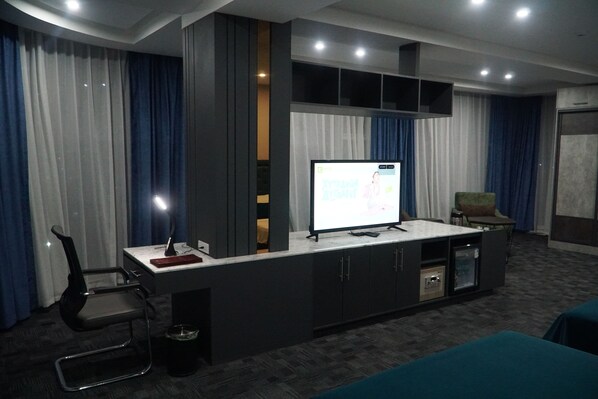 Habitación de lujo, vista a la ciudad | Área de sala de estar | Televisión LCD de 42 pulgadas con canales digitales