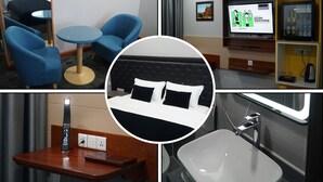 A hotel room with a bed, a TV, a small table, and a bathroom. - Bayantsambagarav Hotel (Olgii)