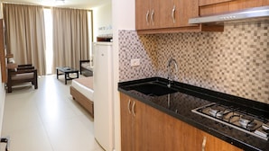Una cocina moderna con armarios de madera, encimera negra y salpicadero de azulejos.