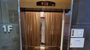An elevator with a digital display indicating the floor number, a sign for Wi-Fi, and a fire extinguisher. - sinchon Y hotel (Seoul)