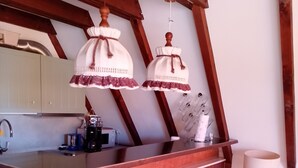 A kitchen with wooden beams, a bar counter, and pendant lights. - Holiday Home 'Bergwiese' with Mountain View, Private Garden and Balcony (Siegsdorf)