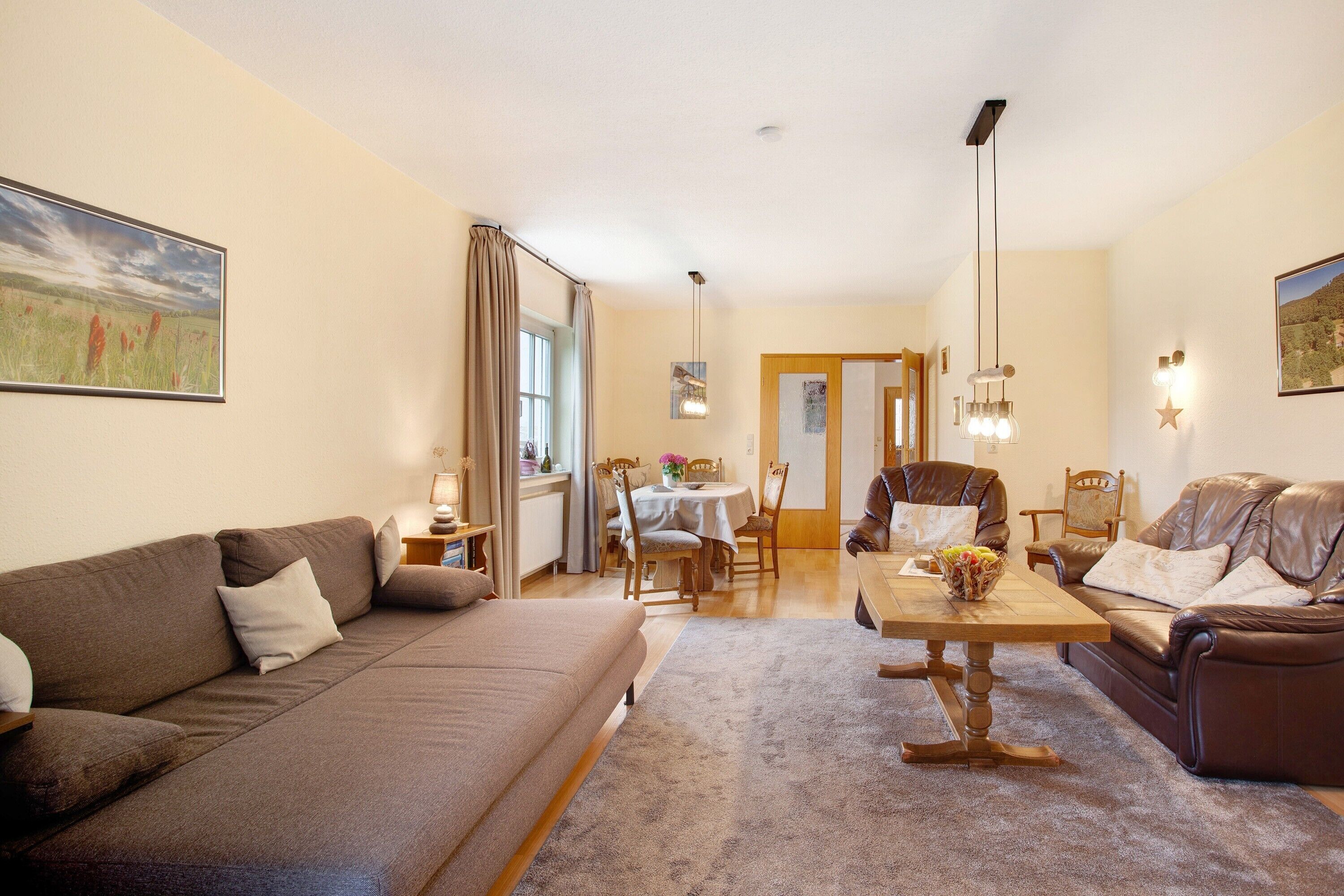 Un salon comprenant un canapé, une table basse et un coin repas avec des chaises et une table.