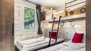 A compact room with bunk beds, a window with a view, and a ladder. - Holiday Home 'Kaperfahrt' with Private Terrace, Wi-Fi and Air Conditioning (Großenbrode)