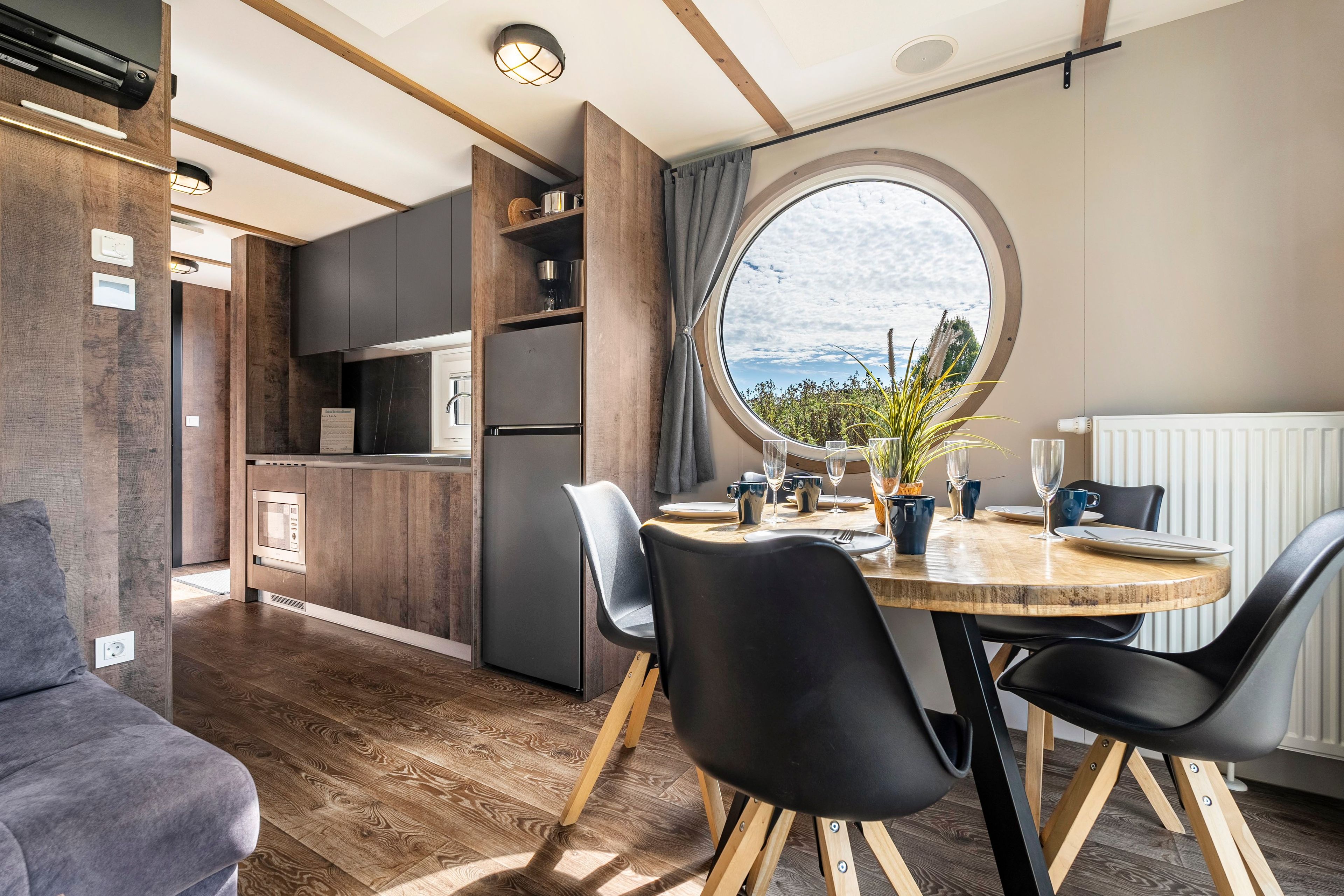 Una cocina moderna con comedor, suelo de madera y vistas amplias a través de un ventanal.