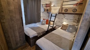 A room with two bunk beds, wooden walls, a ladder, and a curtain. - Holiday Home 'Kaperfahrt' with Private Terrace, Wi-Fi and Air Conditioning (Großenbrode)