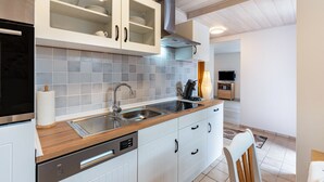A modern kitchen with a wooden countertop, stainless steel appliances, and a built-in dishwasher. - Holiday Apartment "Brigitte" with Mountain View & Wi-Fi (Forbach)