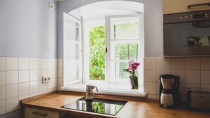 Eine Küche mit Fenster, einer Kaffeemaschine und einem Herd.