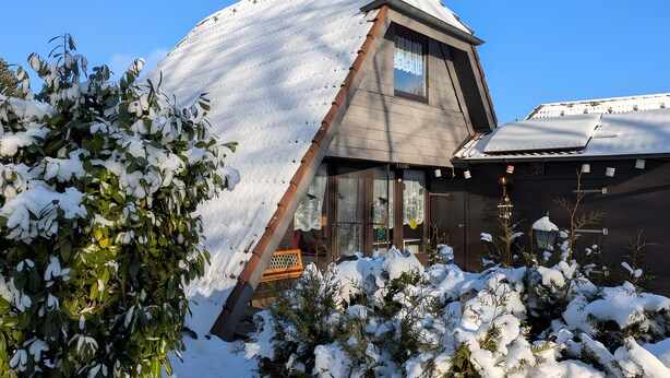 A snow-covered building with a sloped roof, a visible window, and a door. - Holiday Home 'Haus Paradiesecke' with Private Terrace, Garden and Wi-Fi (Waldbrunn)
