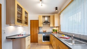 Una cucina moderna con mobili in legno, lavello in acciaio inossidabile e forno integrato.
