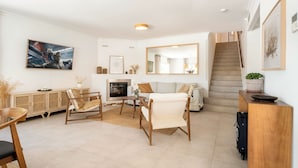 A modern living room with a fireplace, a sofa, a coffee table, and a dining area. - EXCLUSIVE 4 BR VILLA | AMAZING VIEWS | PRIVATE POOL & BBQ (Nueva Andalucía)