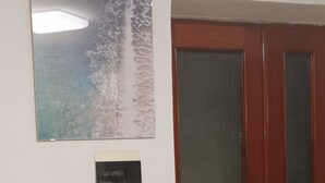 Une pièce avec une porte, un interrupteur et un luminaire fixé au mur.