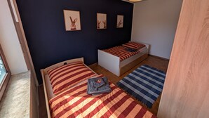 Een slaapkamer met een bed, een zithoekje en een raam.