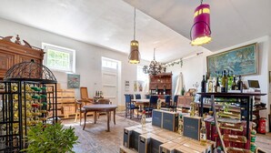 A spacious room with a wooden cabinet, a chandelier, and a table with chairs. - Apartment 'Wohnen Auf Dem Weingut - Klein Und Fein' with Shared Terrace, Shared Garden and Wi-Fi (Maring-Noviand)