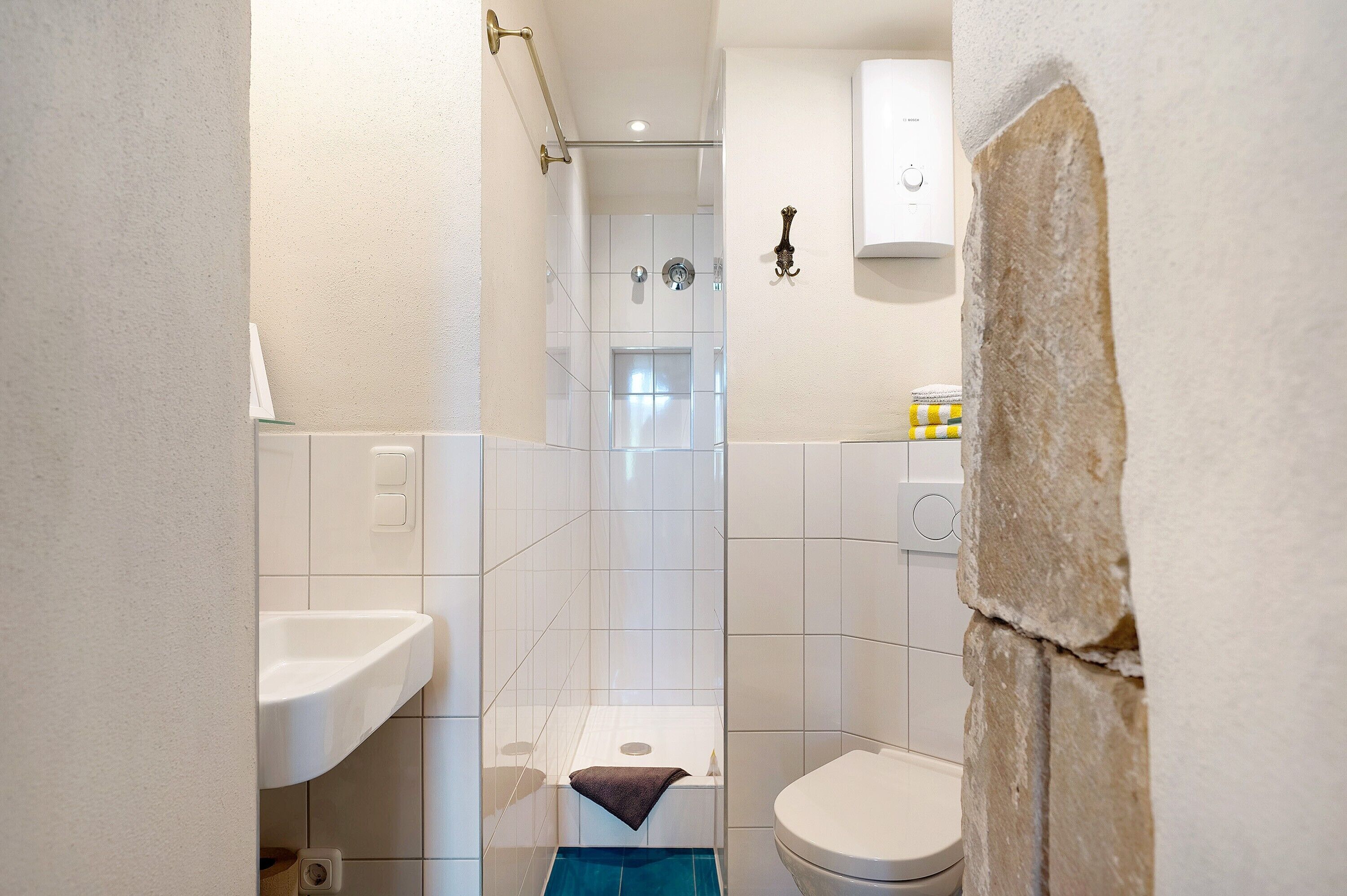 Kylpyhuone, jossa on suihku, wc, pesuallas ja pyyheteline.