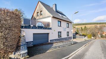 Un bâtiment à deux étages doté d’un garage, d’un balcon et d’une enseigne indiquant qu’il s’agit d’un restaurant.