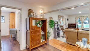 Un salon avec un meuble en bois, un canapé, une télévision et une plante décorative.