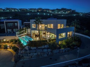A modern two-story house with a swimming pool, outdoor seating, and a stone retaining wall. - Villa Paraiso The View VACATION MARBELLA (Benahavís)