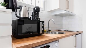 Une cuisine compacte équipée d’un four à micro-ondes, d’une bouilloire et d’un évier.