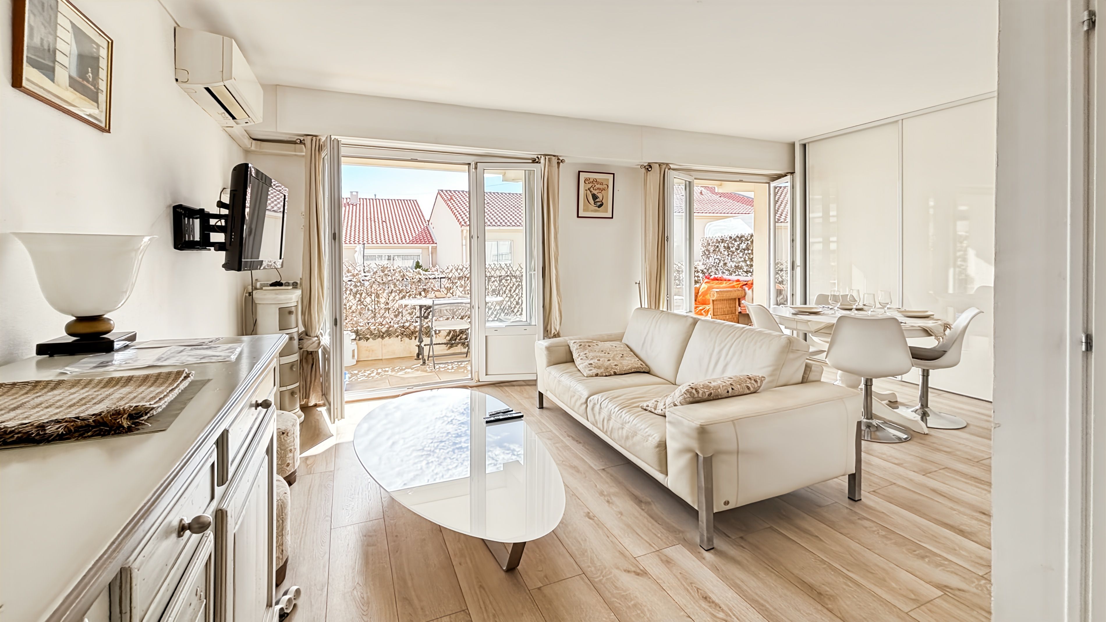A modern living room with a sofa, coffee table, and dining area.