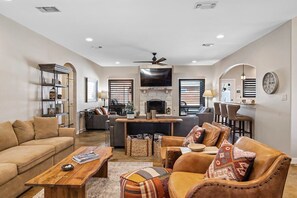 A spacious living room with a sofa, coffee table, and a fireplace.