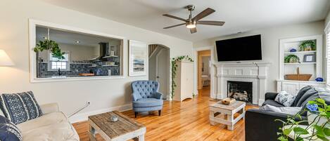 A living room with a fireplace, a television, and a dining area.