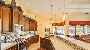 A modern kitchen with wooden cabinets, stainless steel appliances, and a large island.
