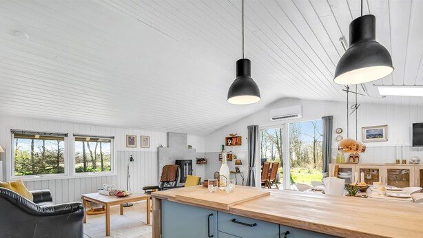 Eine moderne Küche mit Holzarbeitsplatte, Einbauherd und Essbereich mit Tisch und Stühlen.