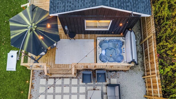 Une terrasse sur le toit équipée d’un jacuzzi, d’un espace salon et d’un grand parasol.