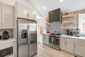 A modern kitchen with stainless steel appliances, a built-in water dispenser, and a gas stove. - Upscale 5BR/3BA w/ Jacuzzi (Oak Park)