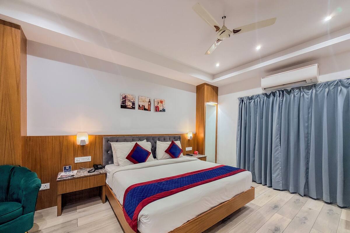 A hotel room with a large bed, wooden headboard, and a ceiling fan.