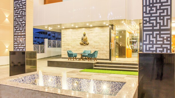 Eine Lobby mit Buddha-Statue, Sitzgelegenheiten und einem Springbrunnen.