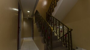 Una escalera con barandillas metálicas ornamentadas y pasamanos, que conduce a un piso superior.