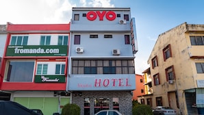 Un hotel llamado 'OYO' con un cartel que dice 'Galeri Pamaran' y 'Fromanda.com' en el edificio contiguo.
