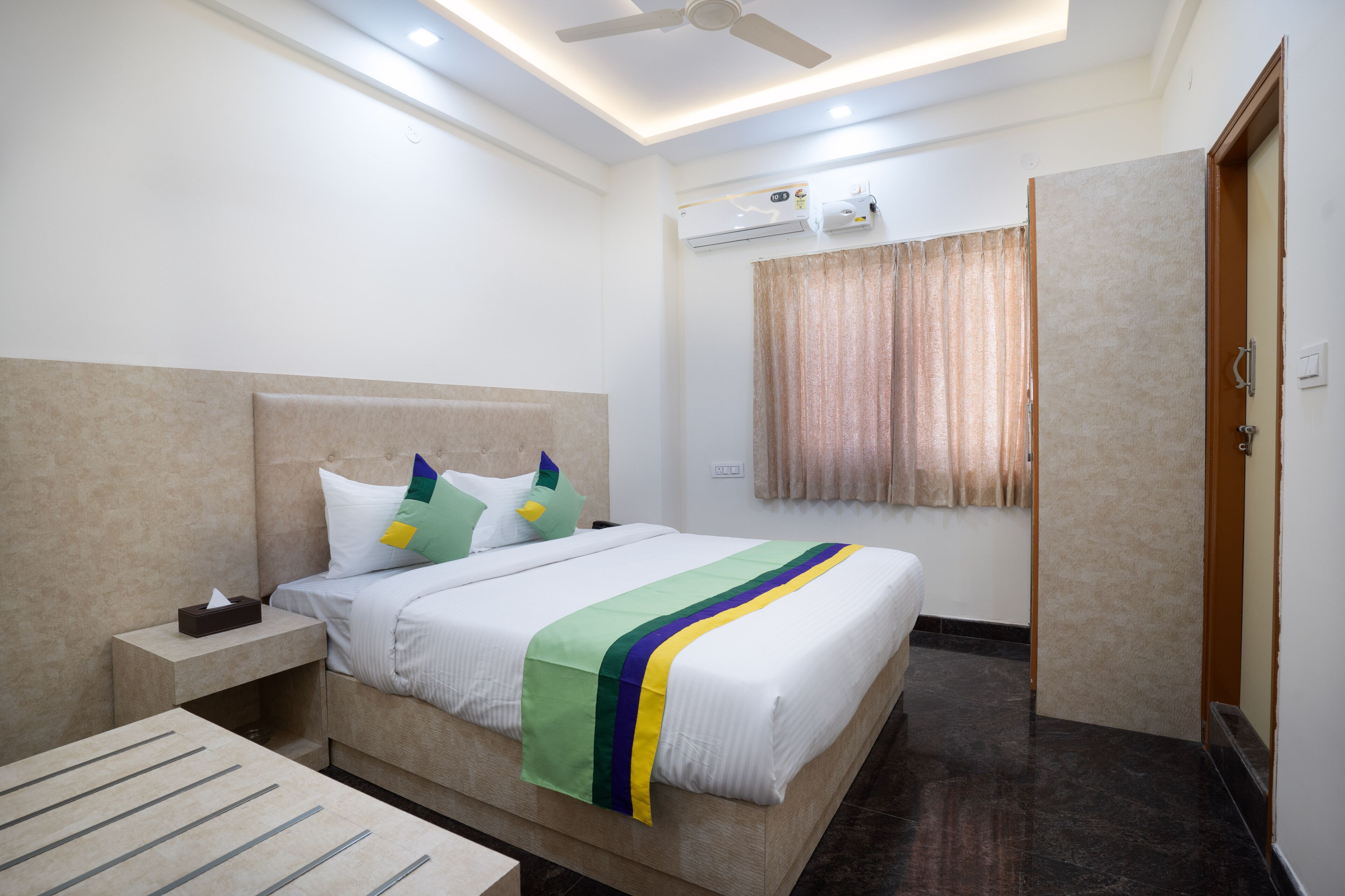 Ein Hotelzimmer mit Bett, Nachttisch und Deckenventilator.