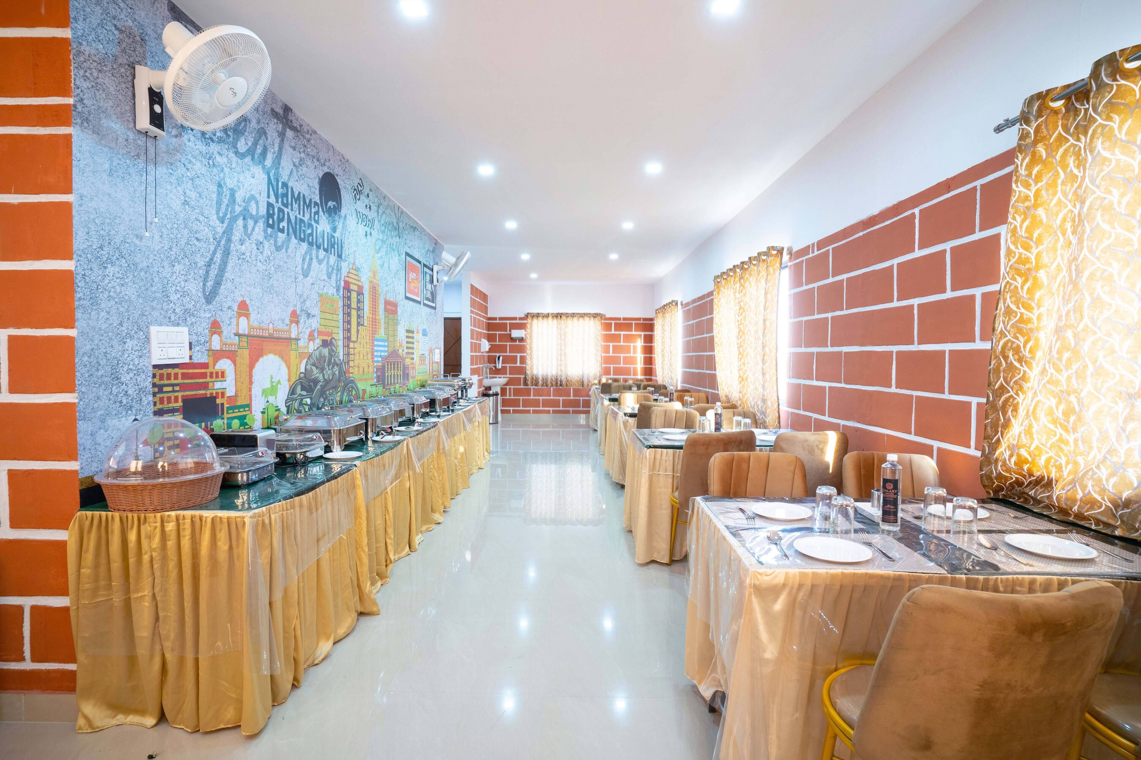 Un restaurante con una barra alargada, cubierta por un mantel dorado, y paredes de ladrillo.