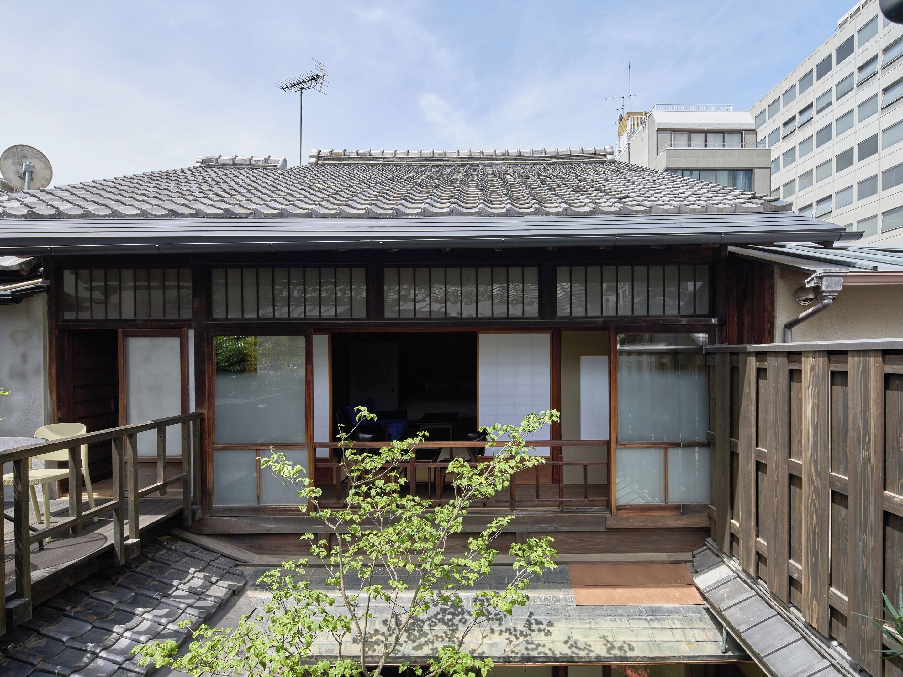 A traditional Japanese-style building with a tiled roof, wooden exterior, and a small porch area.