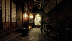 A traditional Japanese courtyard with a wooden gate, a lantern, and a stone pathway. - Kyo no Yado Ishihara (Kyoto)
