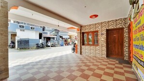 A hotel entrance with a checkered floor, a small brick wall, and a wooden door.