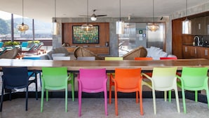 A modern kitchen with a wooden countertop, colorful chairs, and a view of the mountains. - Classy Studio in the heart of Zona Romántica! 1BD Studio for rent in Old Town, (Puerto Vallarta)