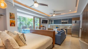 A modern bedroom with a large bed, a sofa, and a view of the kitchen and balcony. - Classy Studio in the heart of Zona Romántica! 1BD Studio for rent in Old Town, (Puerto Vallarta)