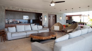A modern living room with a grey sofa, a wooden coffee table, and a wicker chair. - Classy Studio in the heart of Zona Romántica! 1BD Studio for rent in Old Town, (Puerto Vallarta)
