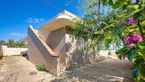A modern building with a curved facade, a paved driveway, and surrounding greenery. - Villa Dei Fanti - Beachfront Villa With Garden (Lecce)