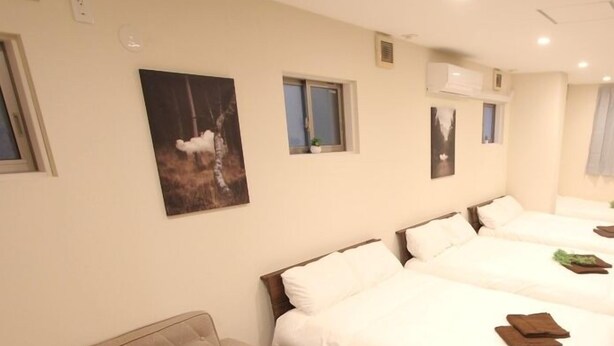A hotel room with a bed, a sofa, and a small window. - LUANA Koenji (Tokyo)