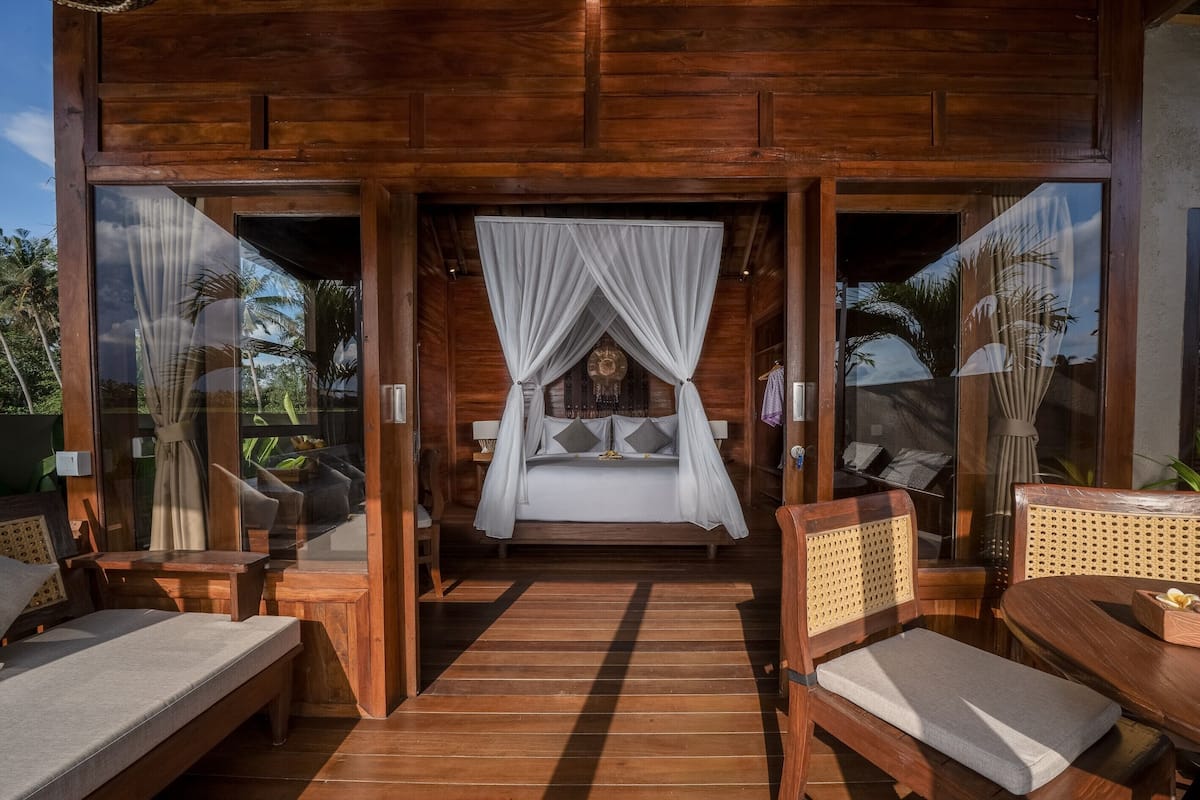 A wooden room with a bed, a table, and chairs.